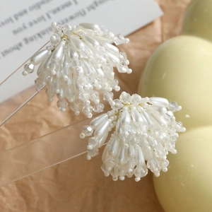 Gros plan de boucles d'oreilles grappes avec perles gouttes blanches et perles facettées