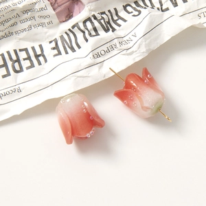 Macro detail of tulip-shaped acrylic beads with gradient red and green colors and micro beads