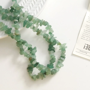 Detalle macro de cuentas de piedra aventurina verde para creación de joyas DIY
