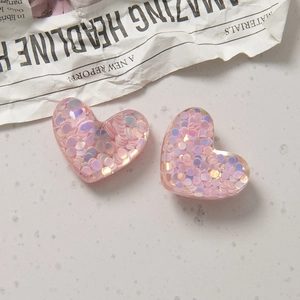 Nahaufnahme von rosa Herz-Harzanhängern mit holografischem Glitzer für DIY-Schmuck