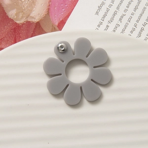 Dettaglio ravvicinato di un accessorio a fiore in acrilico grigio opaco con centro cavo