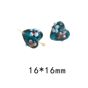 Detail of 16mm heart-shaped blue glass beads with floral and butterfly patterns for DIY