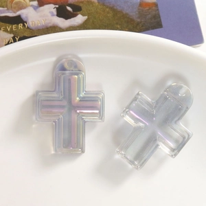 Nahaufnahme von Regenbogen AB Harz-Kreuzanhängern für DIY-Schmuck auf weißem Teller