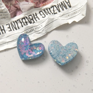 Detail von herzförmigen Harzanhängern mit schimmerndem Glitzer für DIY-Bastelprojekte