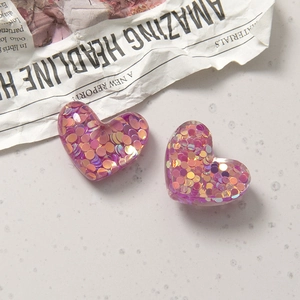 Makroaufnahme von herzförmigen Glitzer-Resin-Anhängern für DIY-Schmuck und Handyhüllen