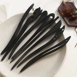Detail of assorted black sandalwood hairpins with minimalist fox and floral carvings