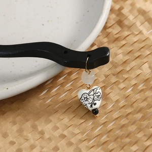 Close-up of black sandalwood hair stick with heart porcelain flower pendant