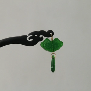 Detail of sandalwood hairpin featuring a green ruyi pendant and golden metal links