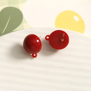 Macro detail of red resin round bead earring components with smooth glossy finish
