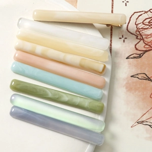 Minimalist marble pattern acetate resin hair clips in various pastel colors on a tray