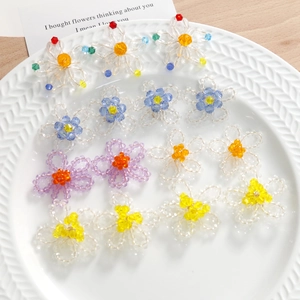 Macro de breloques de fleurs perlées colorées dans un plat en céramique texturée