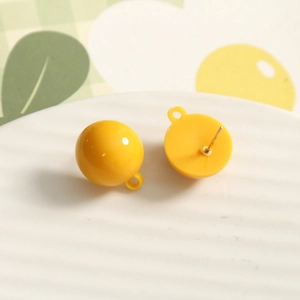 Macro shot of bright yellow resin ball earrings with hanging loop and silver metal pins