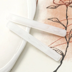 Macro detail of long rectangular resin hair clips with elegant white marble texture finish