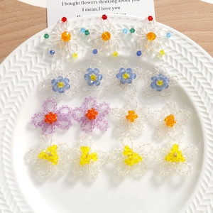 Boucles d'oreilles fleurs en perles de cristal faites main sur un plateau en céramique