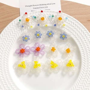 Détails macro de boucles d'oreilles fleurs en perles de cristal sur un plateau blanc