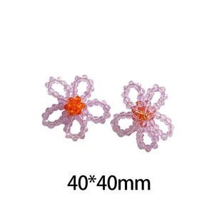Détail d'une fleur faite main de 40x40mm en perles de cristal violettes et cœur orange