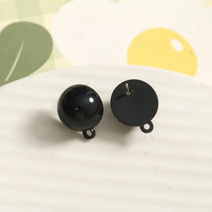 Macro shot of black sphere charms and disk stud earrings bases with loops for DIY jewelry