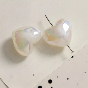 Macro view of pearlescent heart charms with metal pin for DIY jewelry making