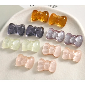 DIY resin bow charms in various translucent glitter colors arranged on a decorative plate