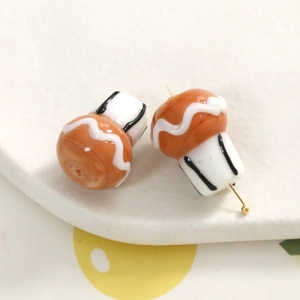 Macro-opname van handgemaakte glazen paddenstoelbedels met gouden pinnen voor sieraden