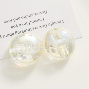 Macro view of colorful iridescent resin beads with engraved text for DIY accessories