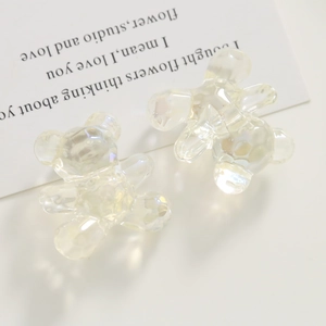 Macro detail of bear-shaped hair clips with iridescent finish on a white prop card