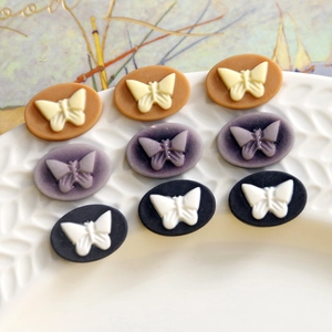 Vintage matte resin oval butterfly charms in caramel, lavender, and navy blue tones