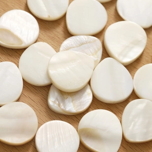 Macro shot of natural white shell pendants with iridescent luster for DIY jewelry making