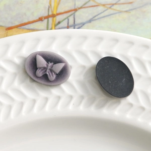 Macro shot of oval vintage butterfly resin charms with detailed purple 3D wings texture