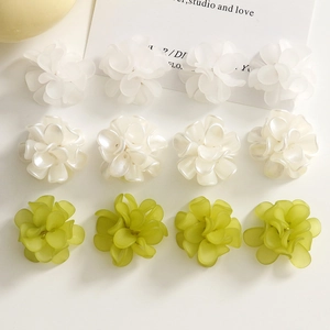 Macro detail of acrylic matte flower charms for DIY jewelry in white and green