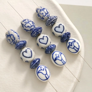 Macro shot of blue and white porcelain beads with floral heart motifs for DIY jewelry