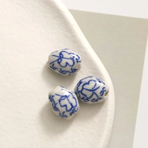 Close-up of hand-painted blue and white porcelain beads for DIY jewelry making