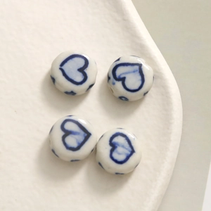 Detailed view of heart-patterned blue and white porcelain flat ceramic beads for DIY jewelry