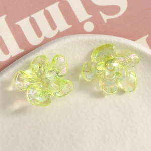 Close-up of iridescent light green resin flower charms with 3D five-petal petal detail
