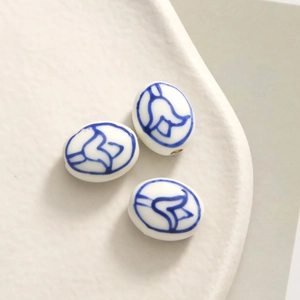 Close-up of three blue and white porcelain oval beads for DIY jewelry making