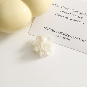 Macro view of creamy white acrylic flower cluster earring component with pearl finish