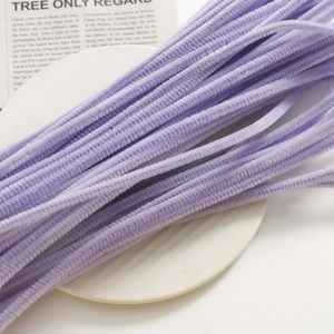 Close-up of lavender purple velvet DIY craft stems arranged on a white ceramic plate