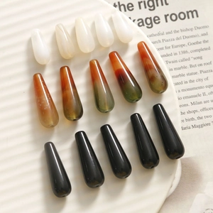 Gradient agate water drop beads in three colors arranged on a white ceramic tray