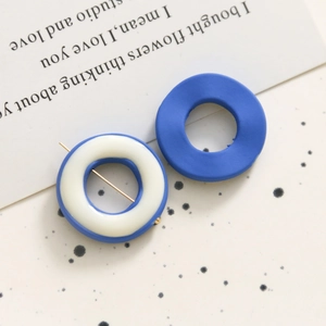 Primer plano detallado de dijes geométricos de resina azul y blanca para accesorios DIY