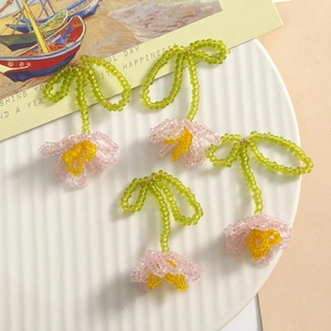 Handmade beaded lily of the valley earrings with pink petals and green bow detail
