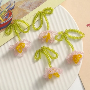 Detailed view of handmade pink tulip beads with green stems for DIY jewelry making