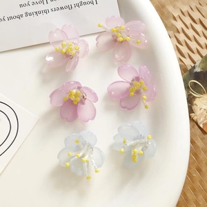 Detalle de coloridos dijes de flores de acrílico para la creación de joyas DIY