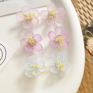 Detalle de dijes de orquídeas en resina de colores para joyería DIY en rosa y azul claro