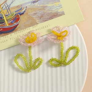 Detail of handmade beaded tulip earrings with pink flower petals and green heart-shaped stems