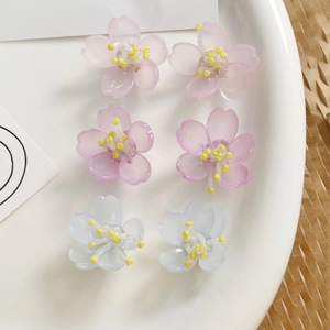 Detalle de componentes para pendientes de flores de resina en rosa, morado y azul