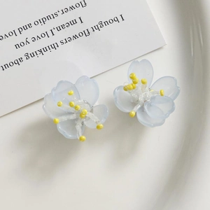 Primer plano de pendientes de orquídea azul claro con centros de cuentas amarillas