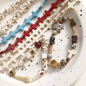Detailed view of vintage cross and starfish beads for DIY ethnic jewelry making