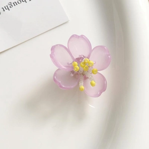 Detalle macro de flor acrílica esmerilada lila con estambres de cuentas amarillas