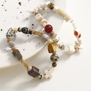Detailed macro of beaded bracelets with stone beads, cross and starfish pendants