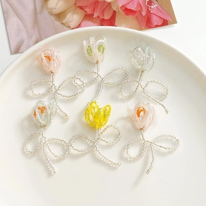 Detailaufnahme von handgefertigten Tulpen-Perlenanhängern in Pastellfarben für DIY-Schmuck